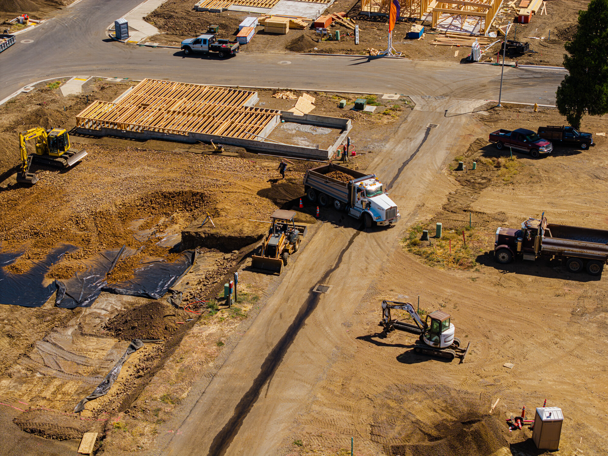 Aerial view of an active residential construction site with crews and equipment